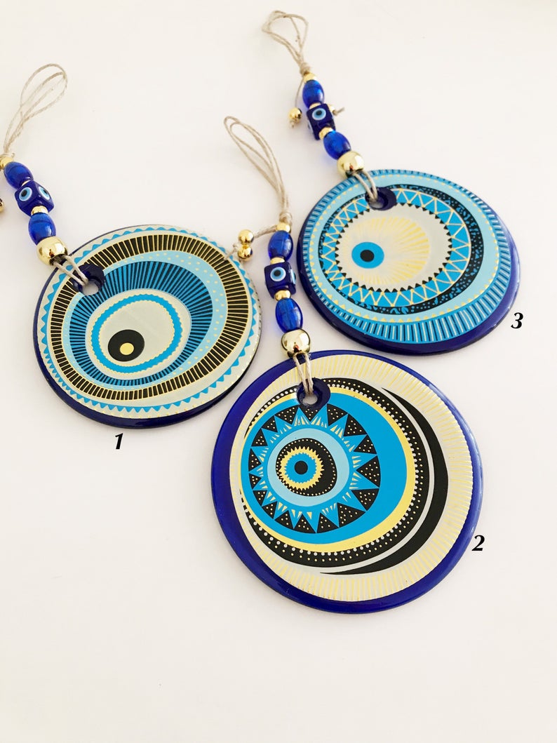 A beautifully crafted Handmade Evil Eye Wall Hanging featuring a large 13cm evil eye bead, showcasing intricate designs and vibrant colors.