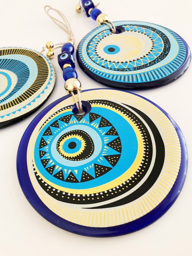 A beautifully crafted Handmade Evil Eye Wall Hanging featuring a large 13cm evil eye bead, showcasing intricate designs and vibrant colors.