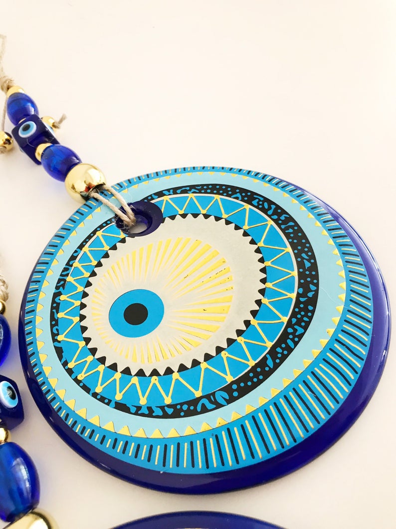 A beautifully crafted Handmade Evil Eye Wall Hanging featuring a large 13cm evil eye bead, showcasing intricate designs and vibrant colors.