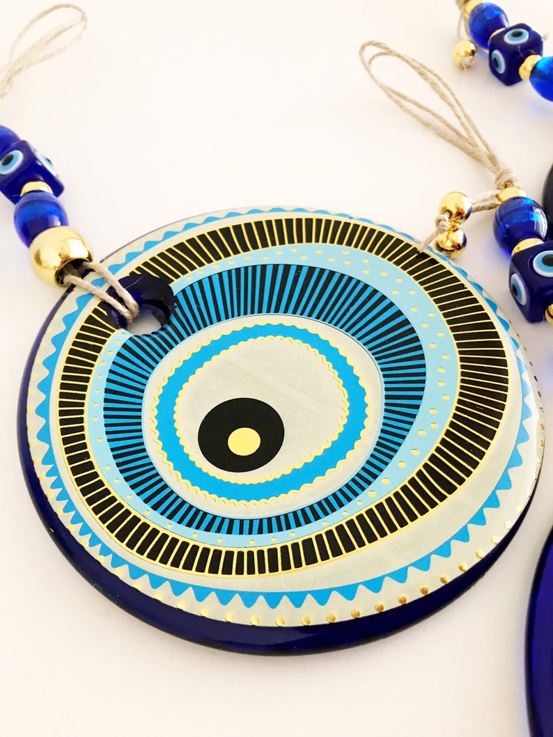 A beautifully crafted Handmade Evil Eye Wall Hanging featuring a large 13cm evil eye bead, showcasing intricate designs and vibrant colors.