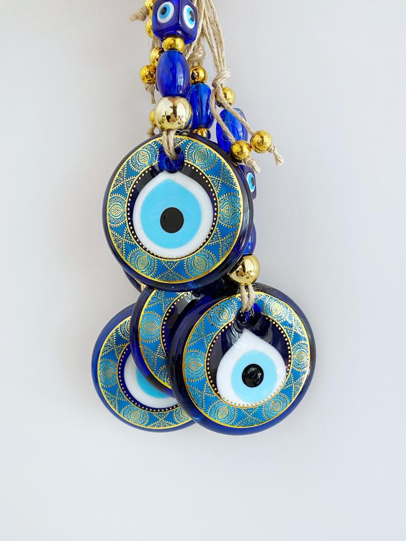 A beautifully crafted Handmade Evil Eye Wall Hanging featuring a vibrant blue evil eye motif, perfect for modern home decor.