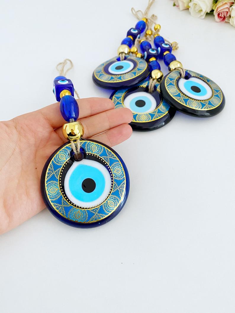 A beautifully crafted Handmade Evil Eye Wall Hanging featuring a vibrant blue evil eye motif, perfect for modern home decor.