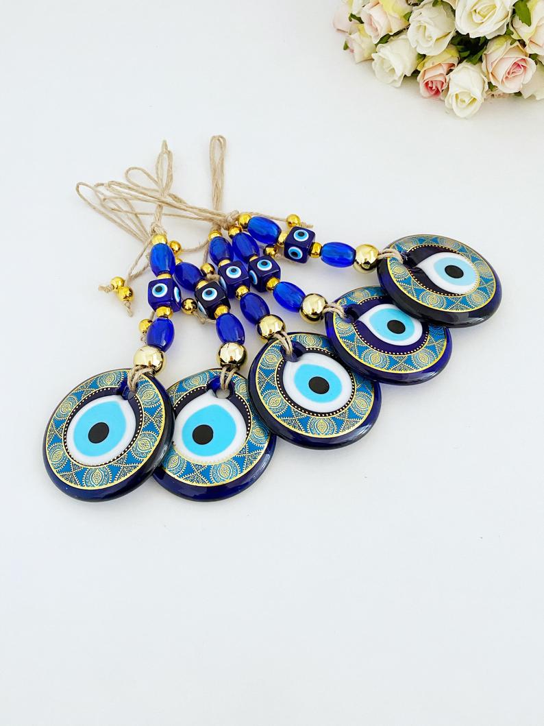 A beautifully crafted Handmade Evil Eye Wall Hanging featuring a vibrant blue evil eye motif, perfect for modern home decor.