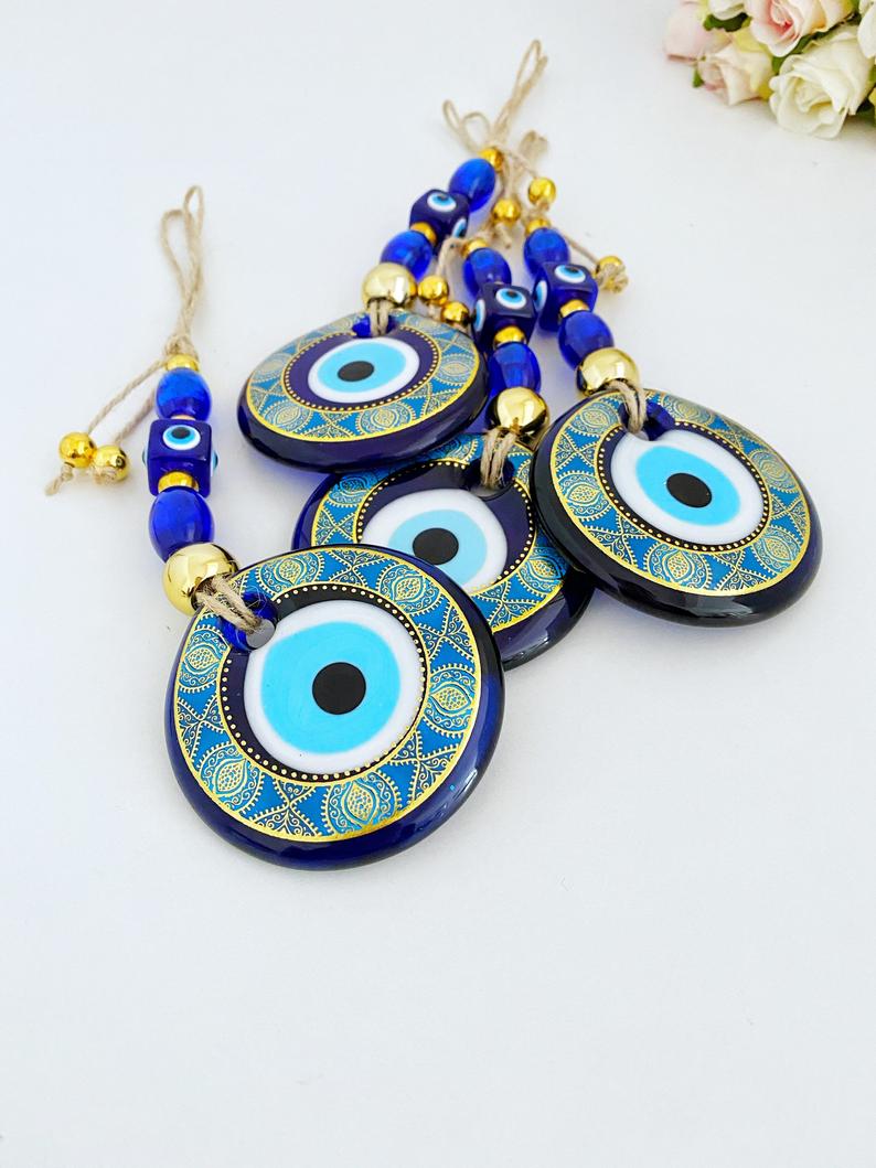 A beautifully crafted Handmade Evil Eye Wall Hanging featuring a vibrant blue evil eye motif, perfect for modern home decor.