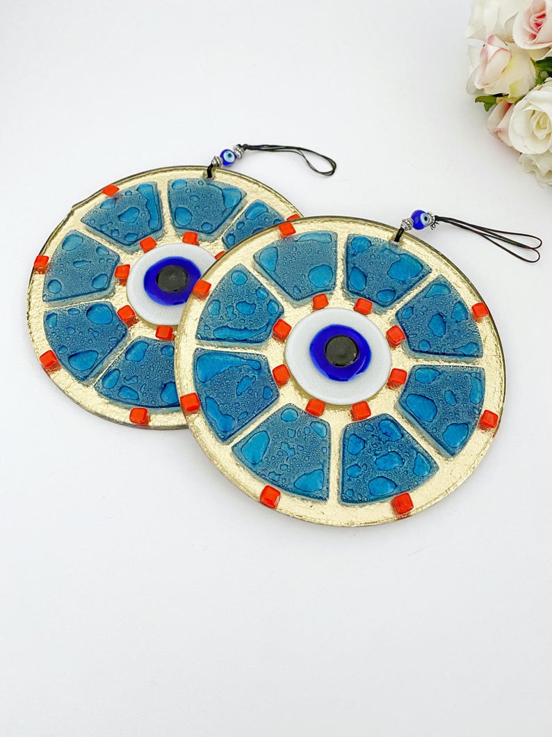 A beautifully crafted handmade glass evil eye bead in blue, featuring intricate designs, perfect for wall hanging and home decor.