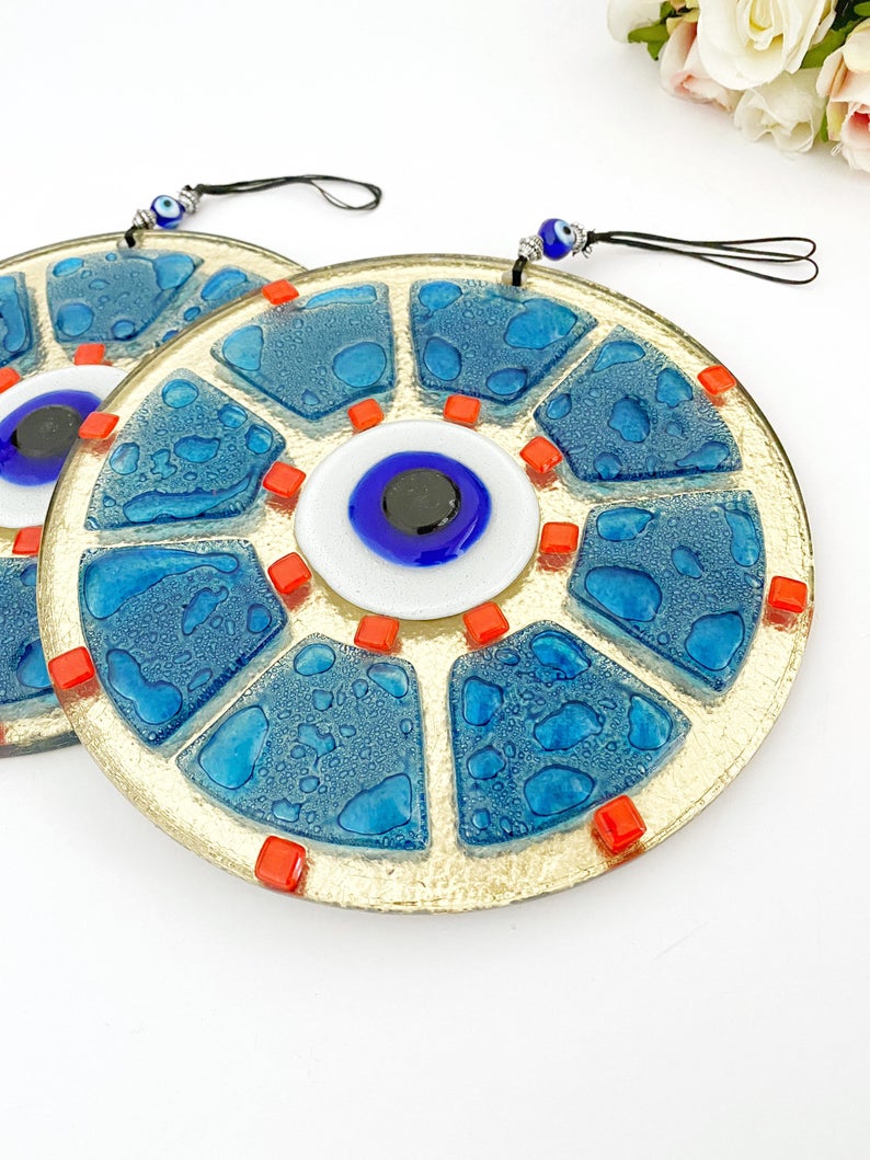 A beautifully crafted handmade glass evil eye bead in blue, featuring intricate designs, perfect for wall hanging and home decor.