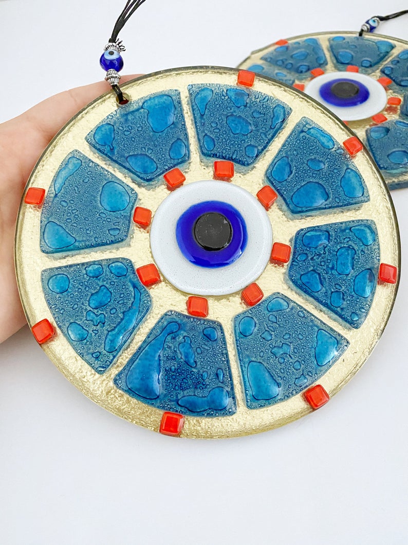 A beautifully crafted handmade glass evil eye bead in blue, featuring intricate designs, perfect for wall hanging and home decor.