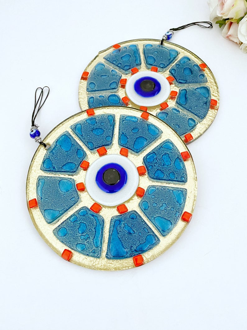 A beautifully crafted handmade glass evil eye bead in blue, featuring intricate designs, perfect for wall hanging and home decor.