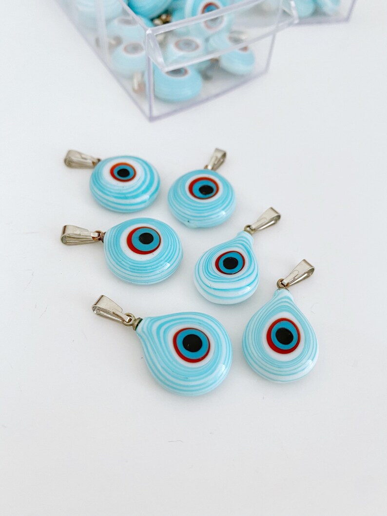 Handmade glass evil eye charm in turquoise, featuring round and oval shapes, perfect for jewelry making.