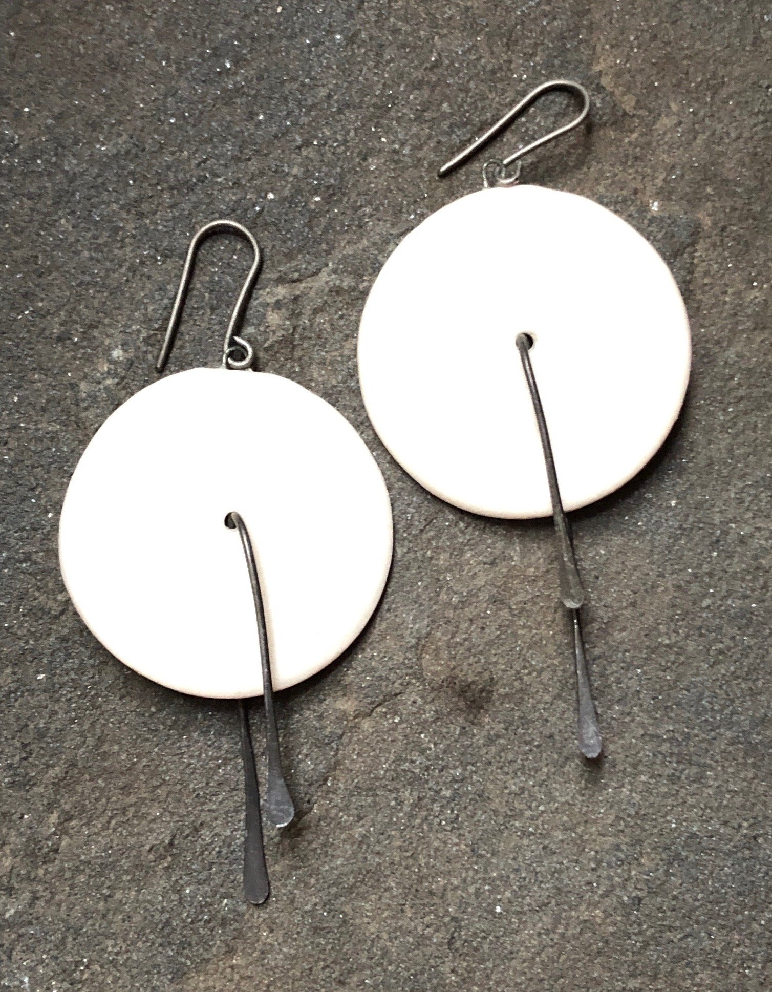 Handmade lightweight ceramic statement earrings with hypoallergenic titanium ear wires, featuring a unique design and 2-inch dangle length.