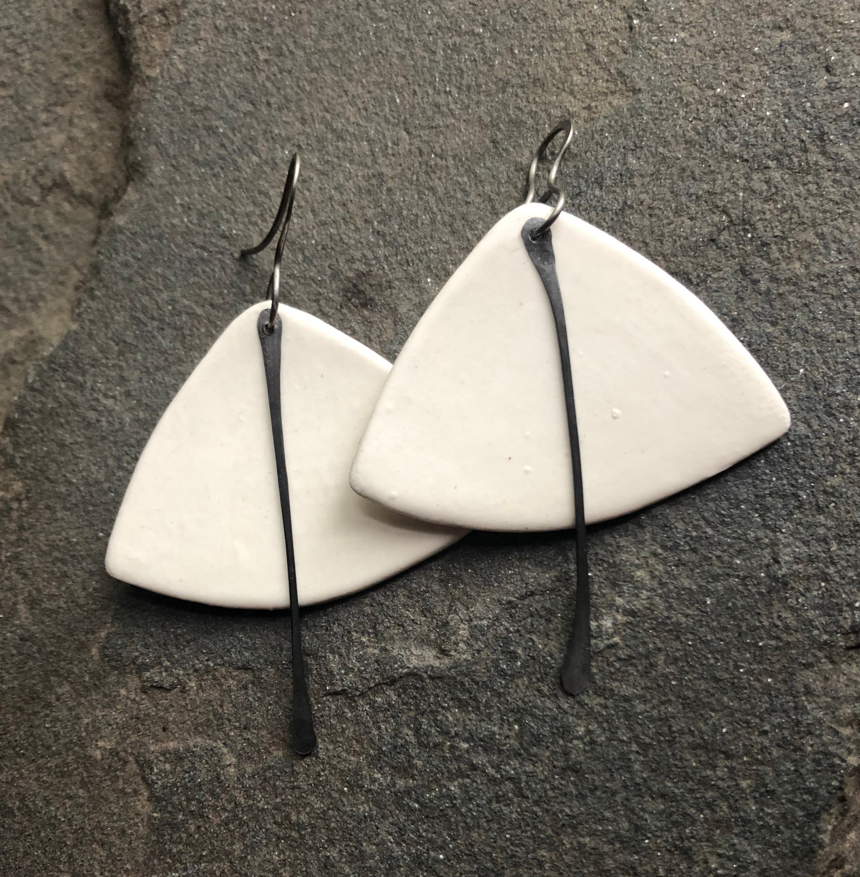 A pair of handmade lightweight ceramic statement earrings featuring hypoallergenic titanium ear wires, showcasing a unique design.