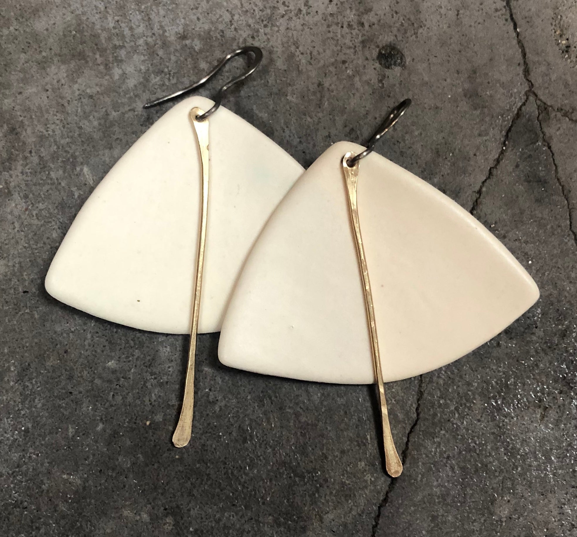 A pair of handmade lightweight ceramic statement earrings featuring hypoallergenic titanium ear wires, showcasing a unique design.