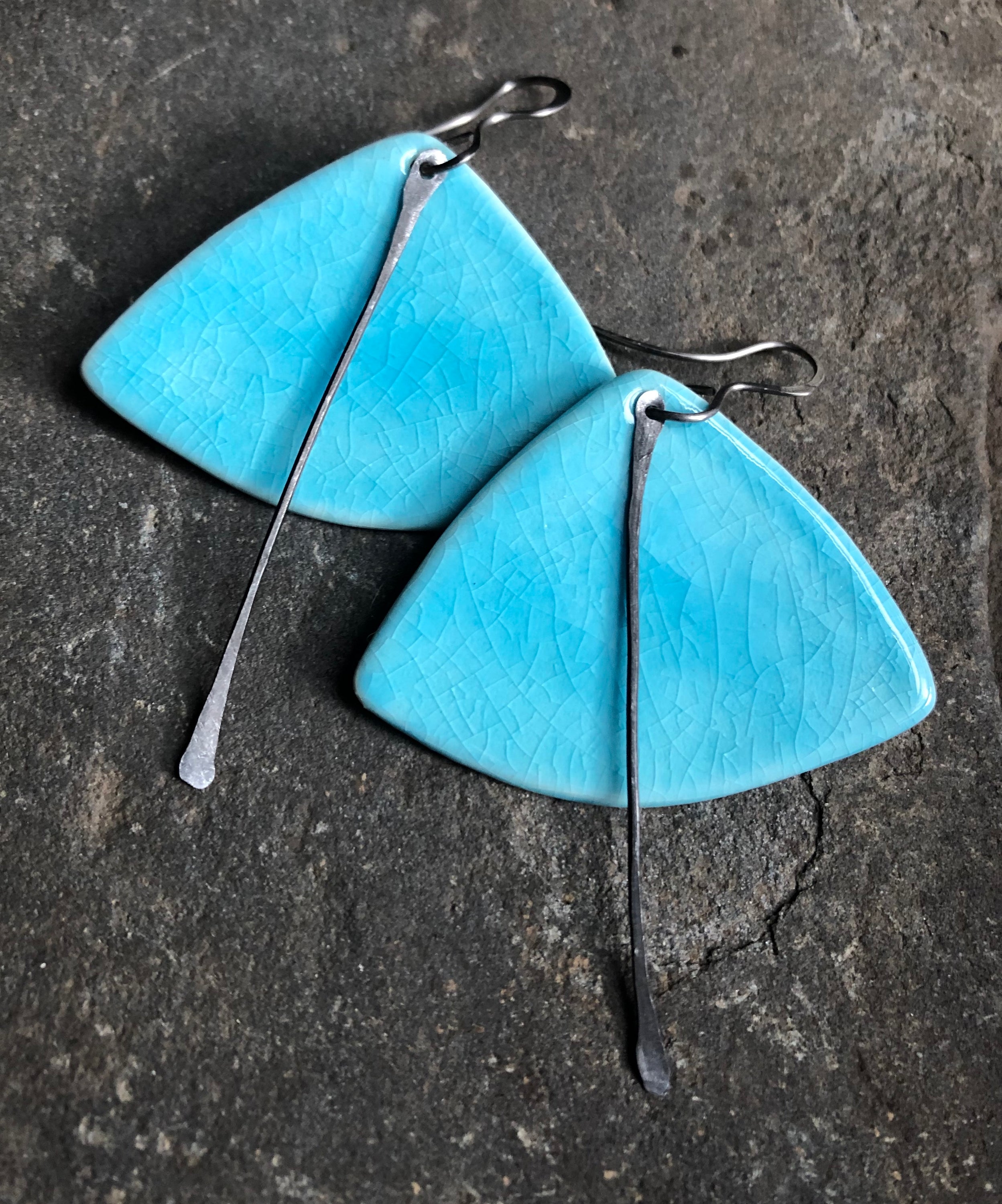 A pair of handmade lightweight ceramic statement earrings featuring hypoallergenic titanium ear wires, showcasing a unique design.