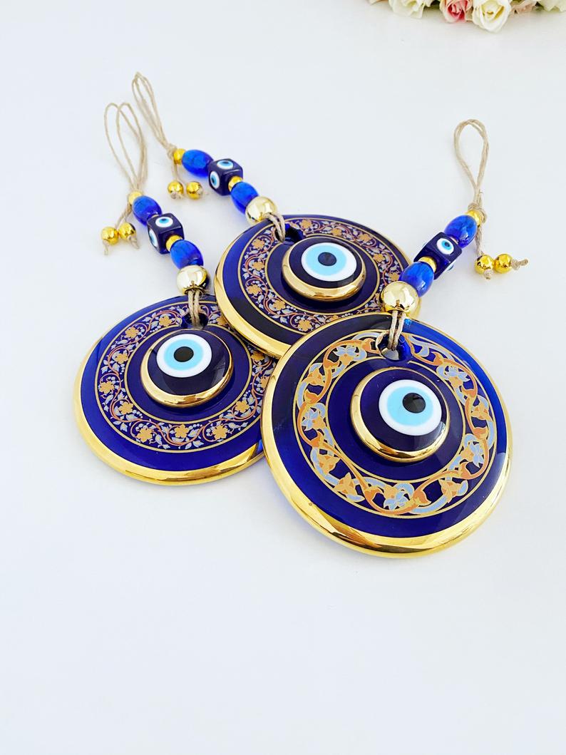 Handpainted Evil Eye Wall Hanging featuring blue glass accents, symbolizing protection and luck, measuring 29cm in length.