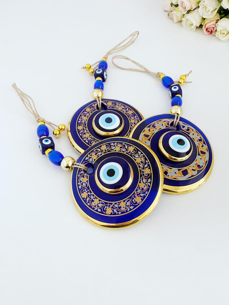 Handpainted Evil Eye Wall Hanging featuring blue glass accents, symbolizing protection and luck, measuring 29cm in length.