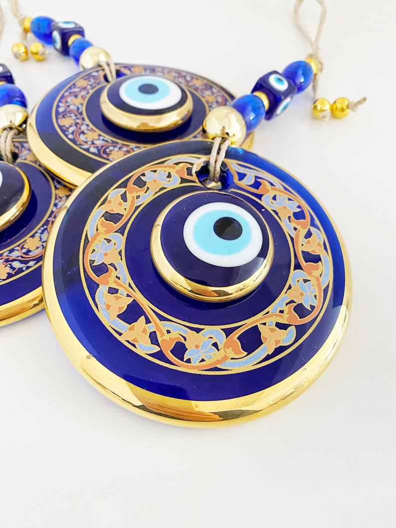 Handpainted Evil Eye Wall Hanging featuring blue glass accents, symbolizing protection and luck, measuring 29cm in length.