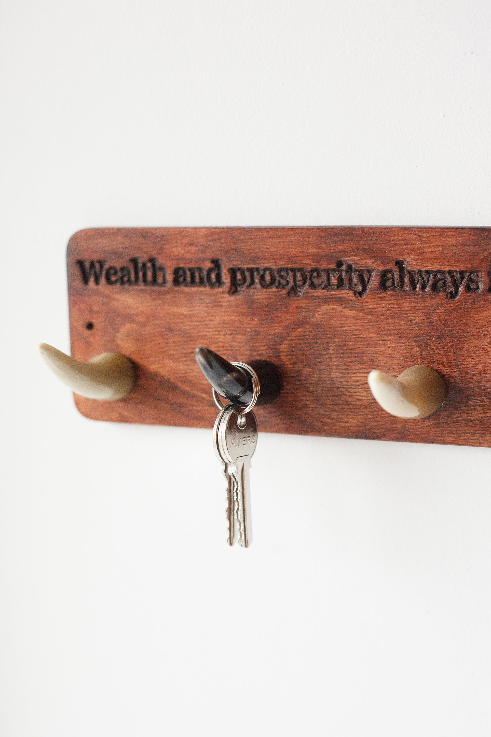 Handmade wooden key hanger featuring polished bull horn hooks, perfect for entryway organization.