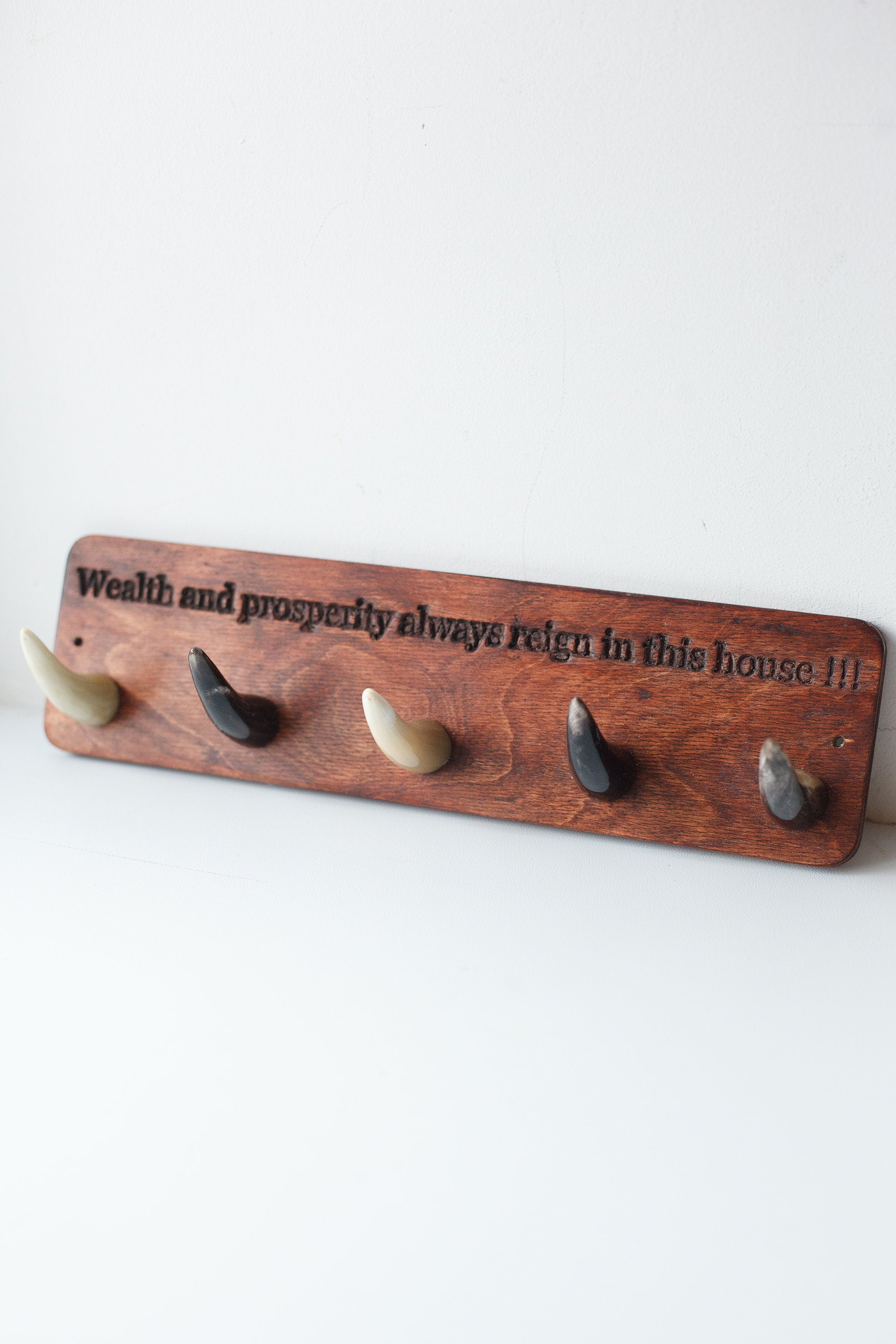 Handmade wooden key hanger featuring polished bull horn hooks, perfect for entryway organization.