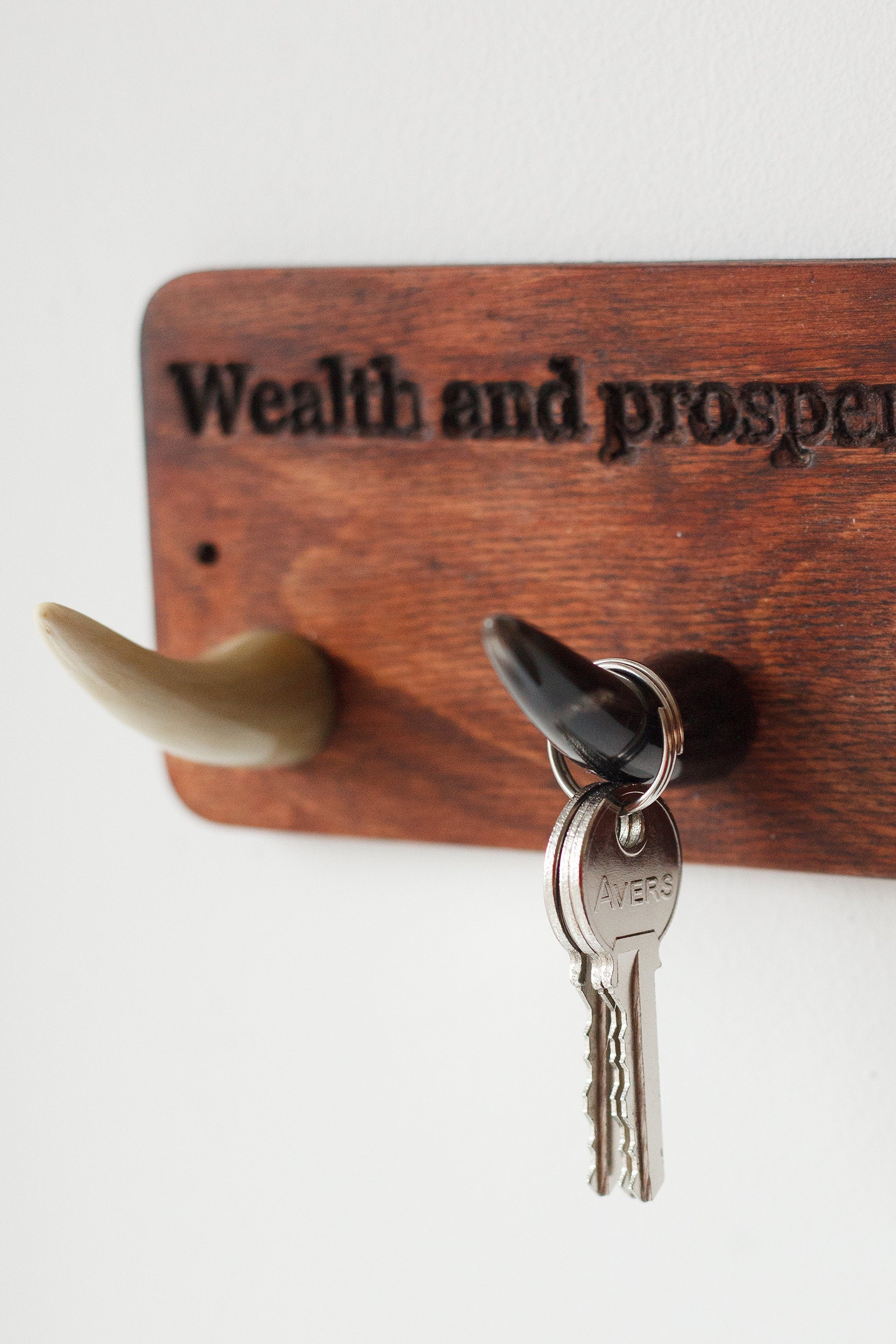 Handmade wooden key hanger featuring polished bull horn hooks, perfect for entryway organization.