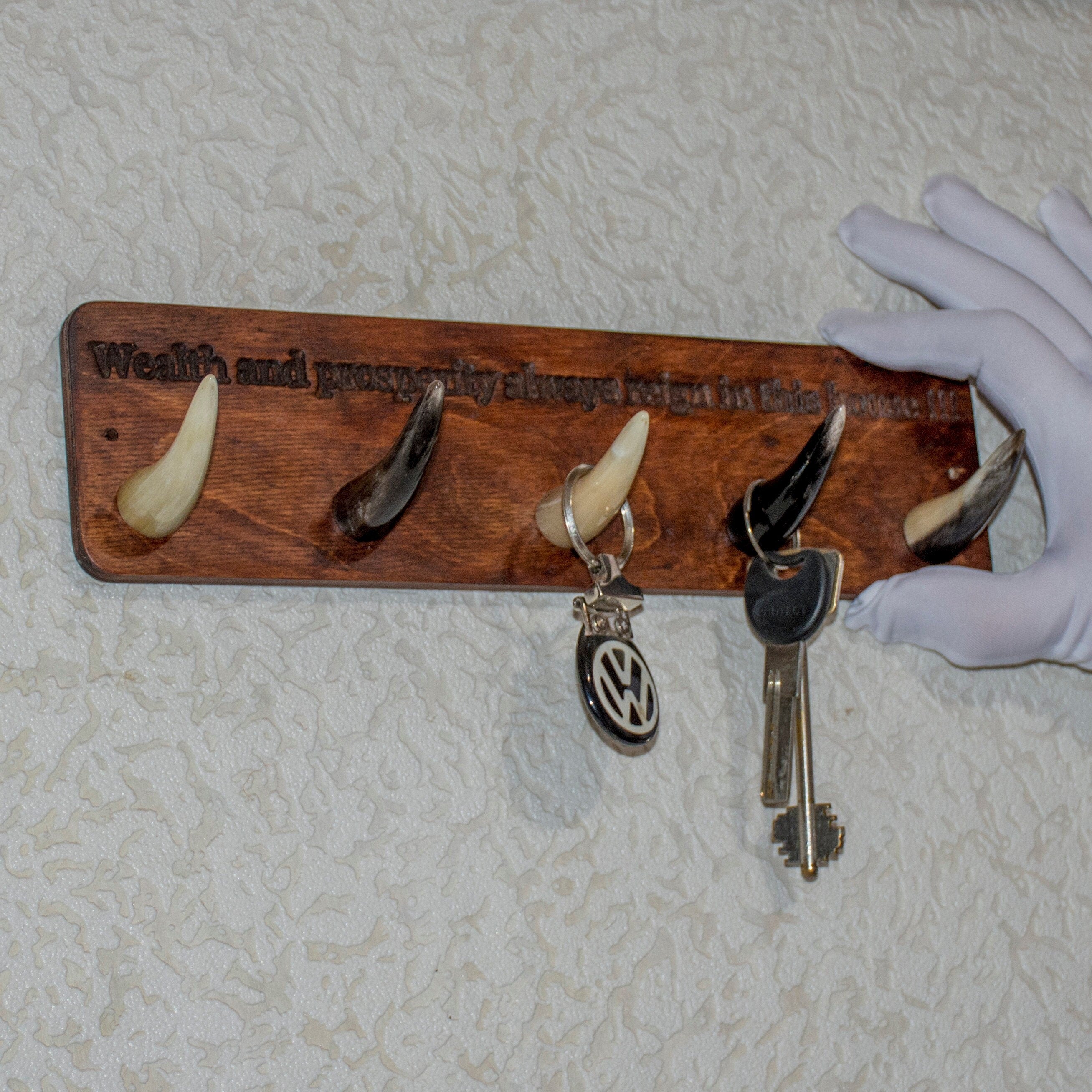 Handmade wooden key hanger featuring polished bull horn hooks, perfect for entryway organization.