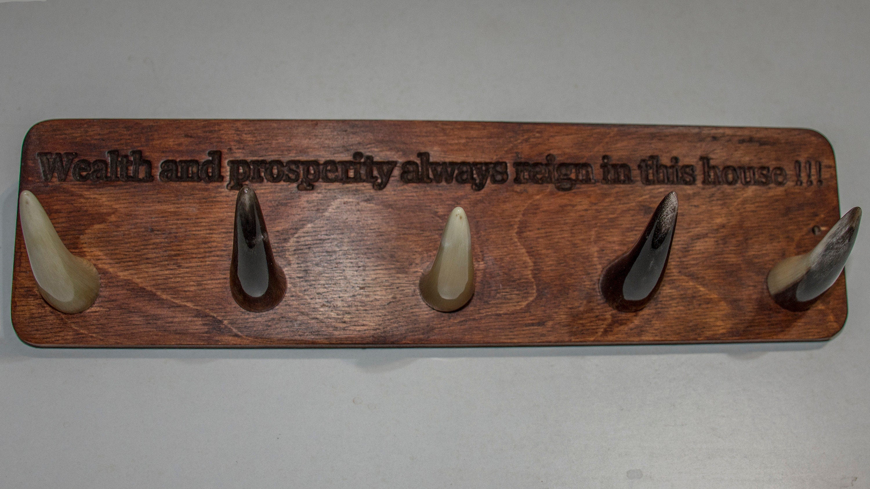 Handmade wooden key hanger featuring polished bull horn hooks, perfect for entryway organization.