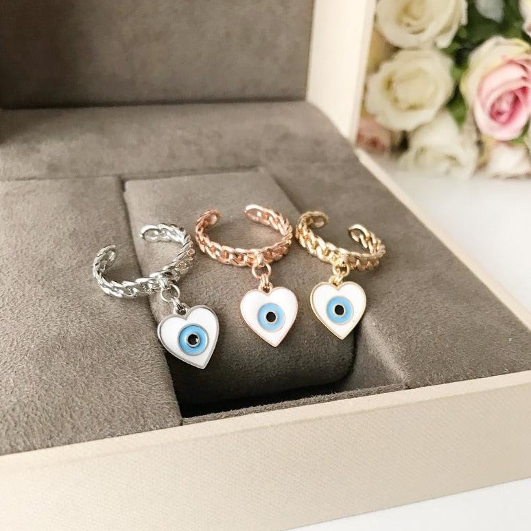 Heart Evil Eye Dangle Ring featuring white evil eye beads and adjustable design in silver, gold, and rose gold finishes.