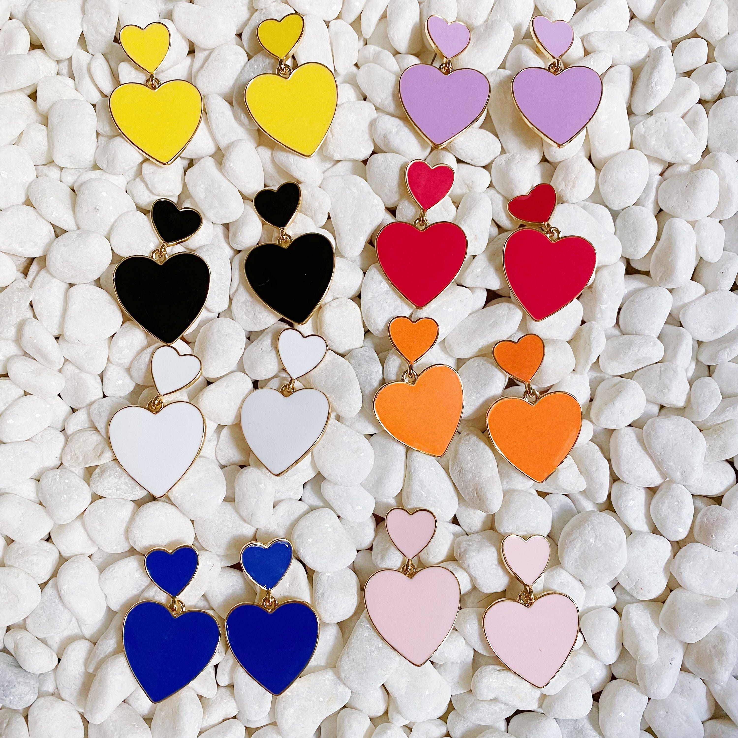 Trendy double heart earrings with glossy enamel finish in gold tone, perfect for game day or casual wear.