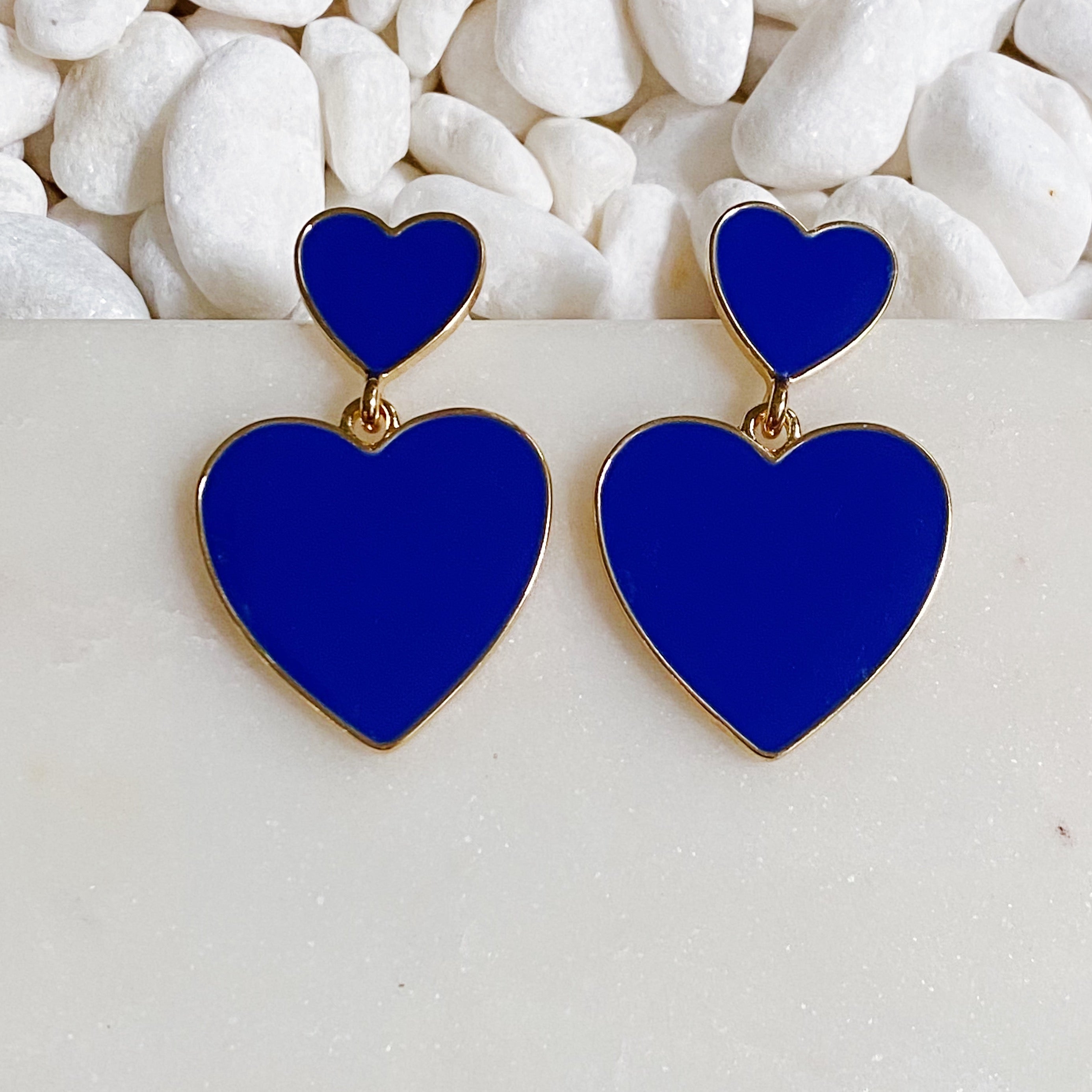 Trendy double heart earrings with glossy enamel finish in gold tone, perfect for game day or casual wear.