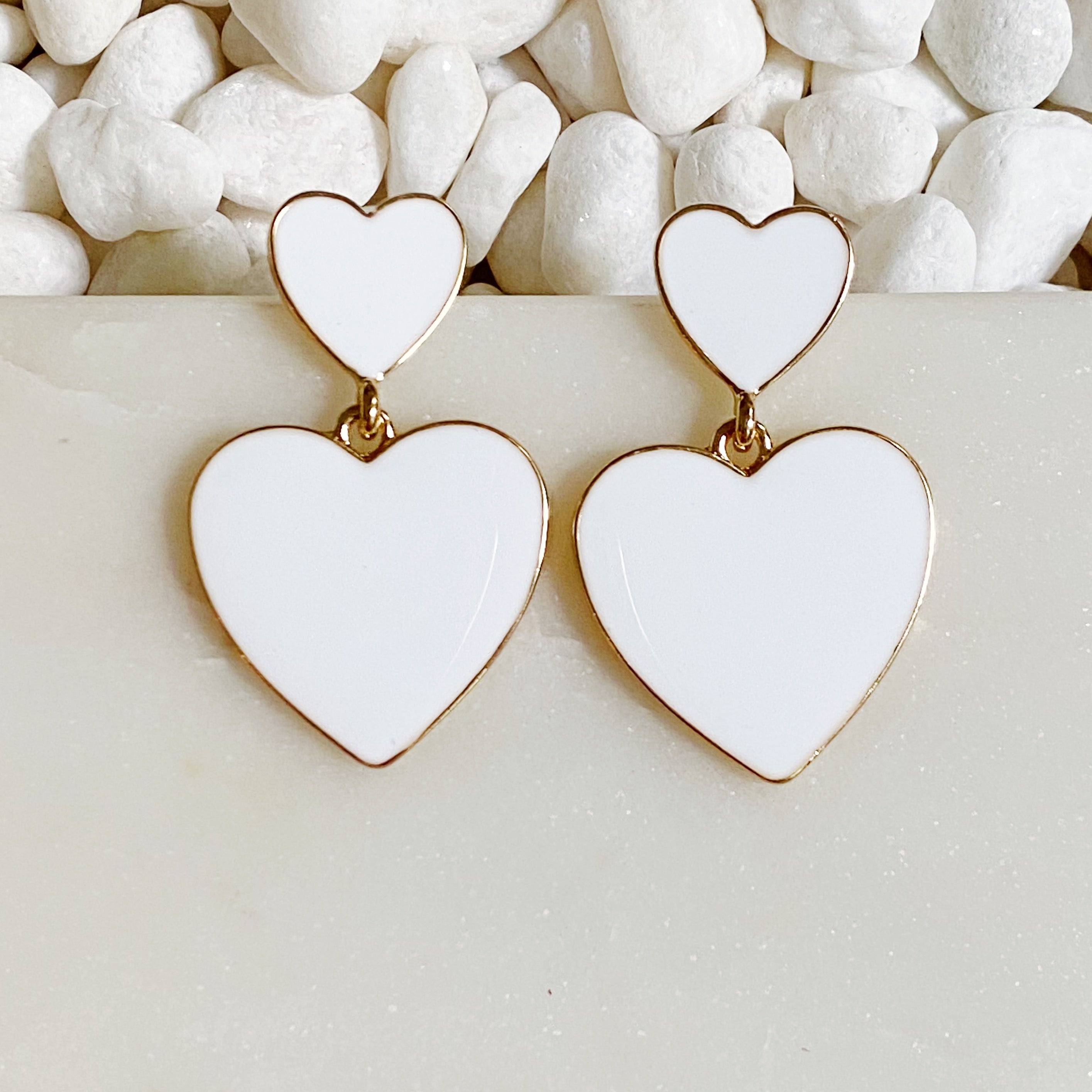 Trendy double heart earrings with glossy enamel finish in gold tone, perfect for game day or casual wear.