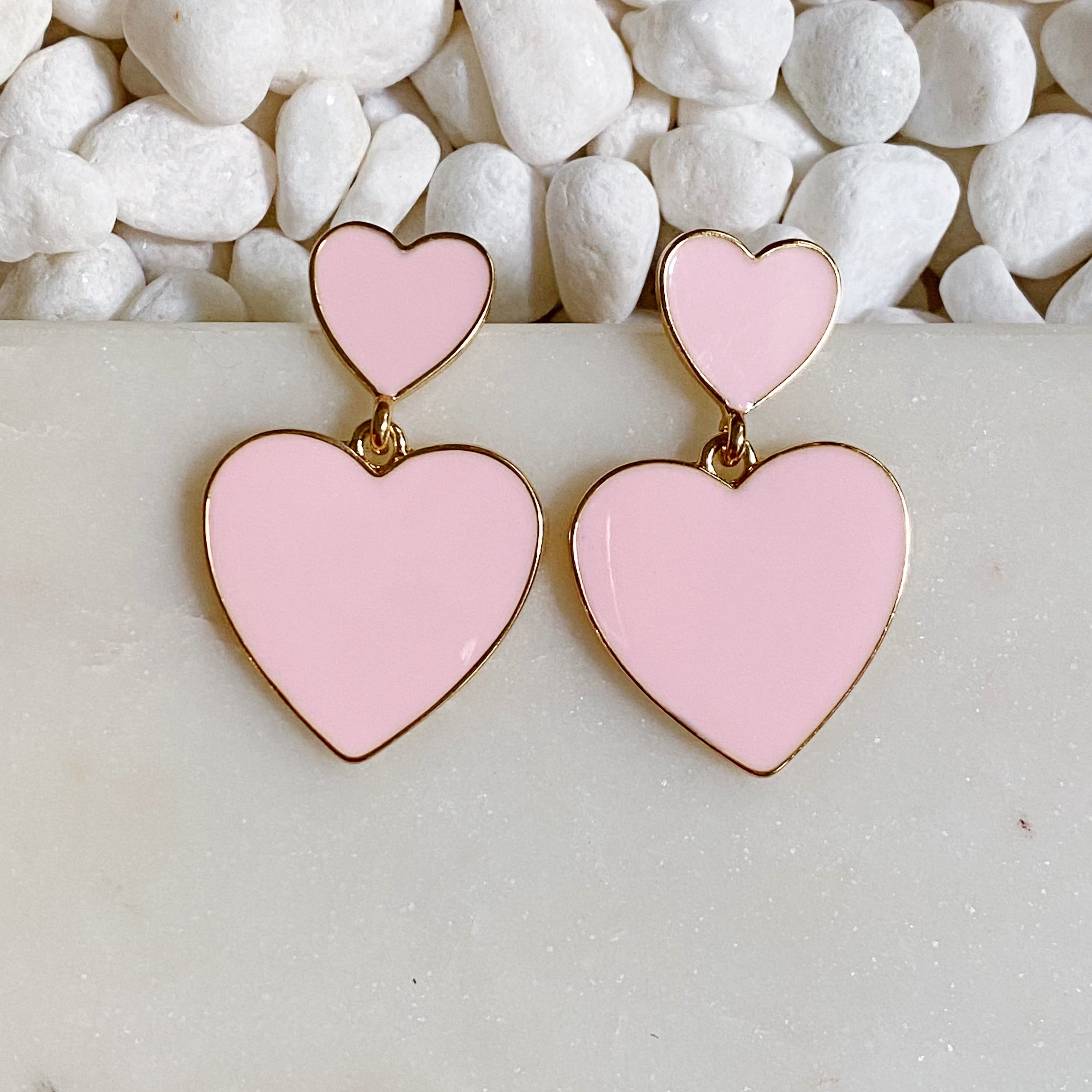 Trendy double heart earrings with glossy enamel finish in gold tone, perfect for game day or casual wear.