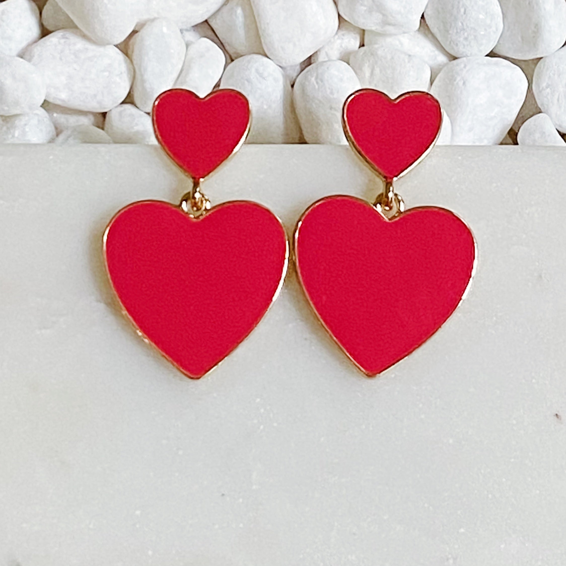 Trendy double heart earrings with glossy enamel finish in gold tone, perfect for game day or casual wear.