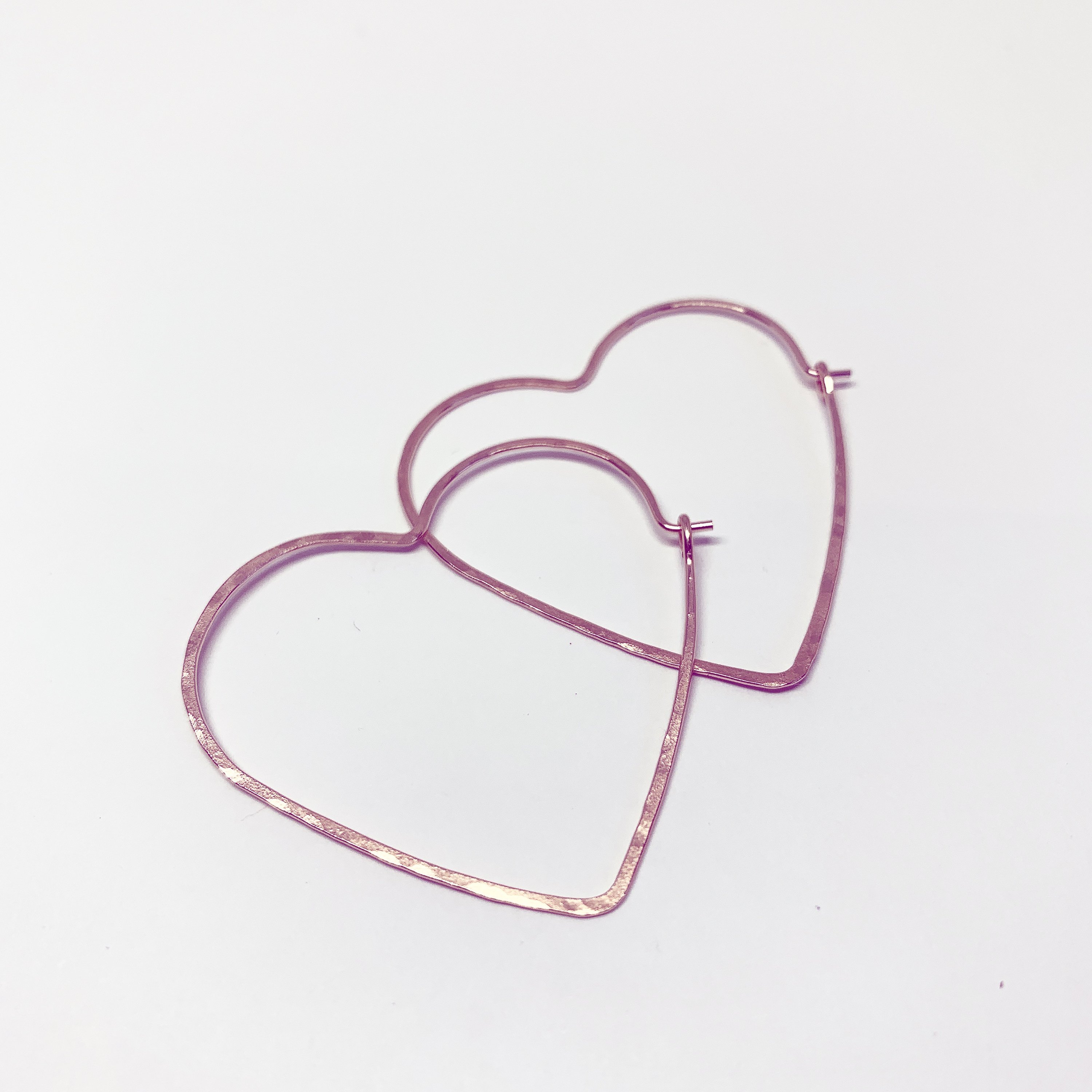 Large heart-shaped hoops made from 20 gauge wire, featuring a hammered texture for shine, available in silver, yellow gold fill, and rose gold fill.