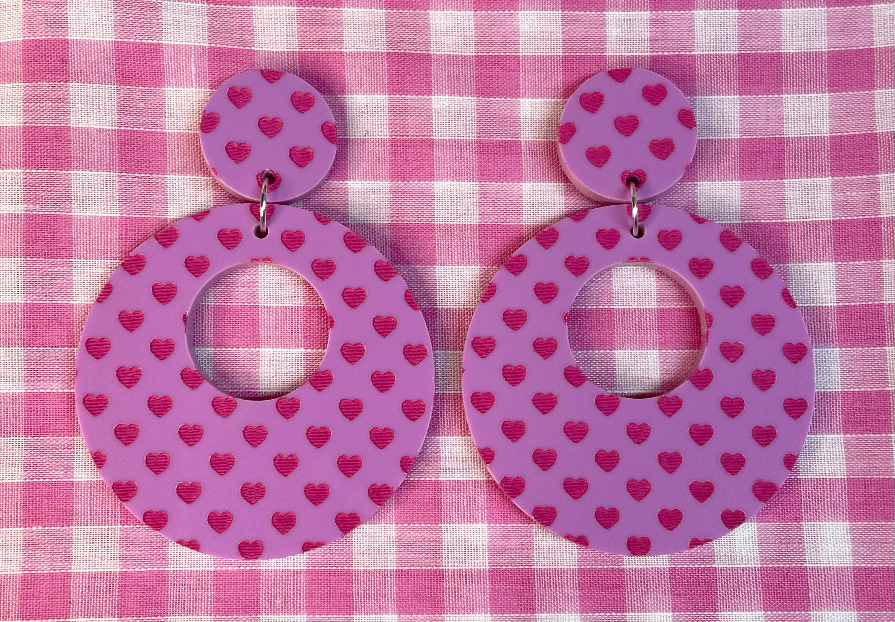 A pair of stylish Heart Print Hoop Earrings featuring a playful heart design, made from laser cut acrylic, showcasing vintage-inspired fashion.