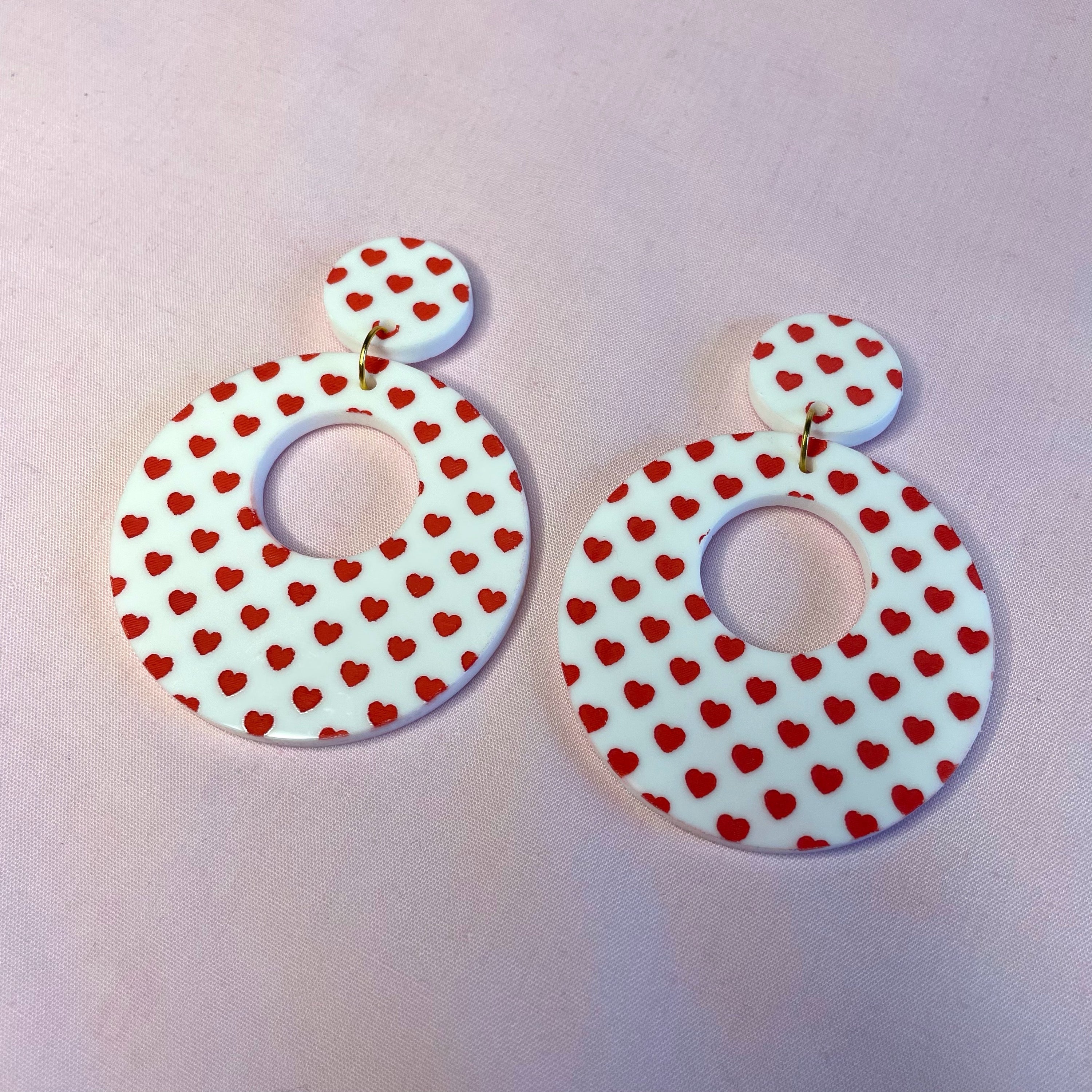 A pair of stylish Heart Print Hoop Earrings featuring a playful heart design, made from laser cut acrylic, showcasing vintage-inspired fashion.