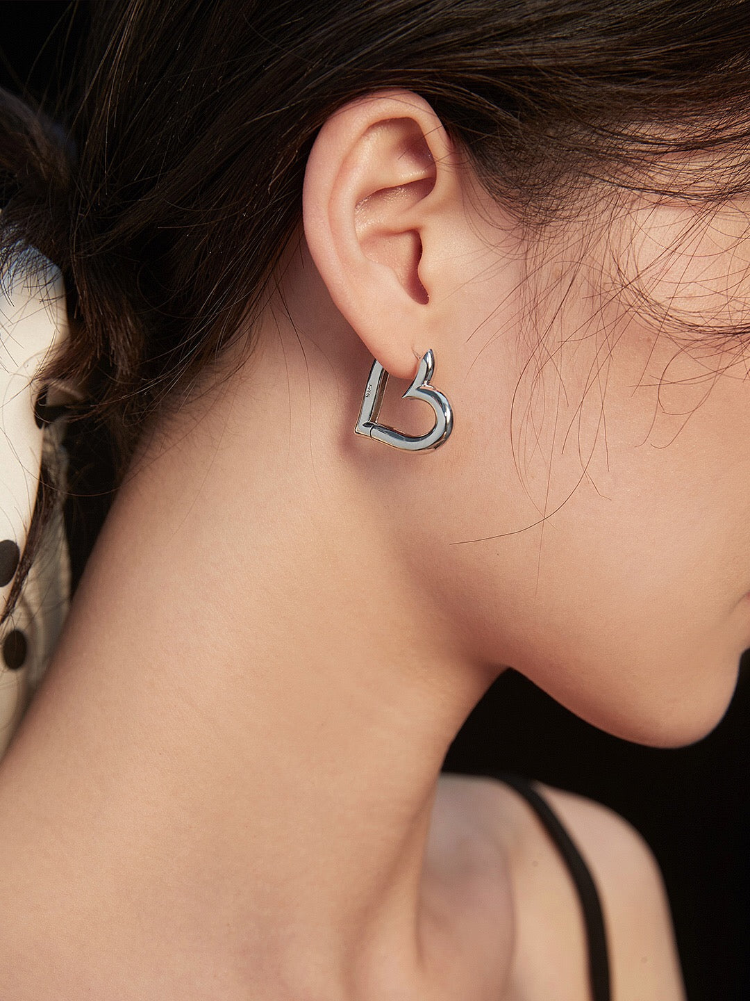 A pair of elegant heart shape hoop earrings made from sterling silver with a gold vermeil finish, showcasing their unique design and craftsmanship.