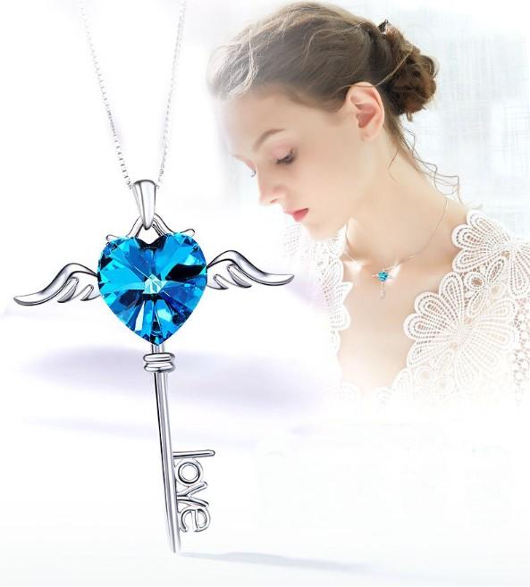 Heart shaped blue elements dangling key necklace in 14K white gold, featuring a beautiful blue pendant and a link chain.