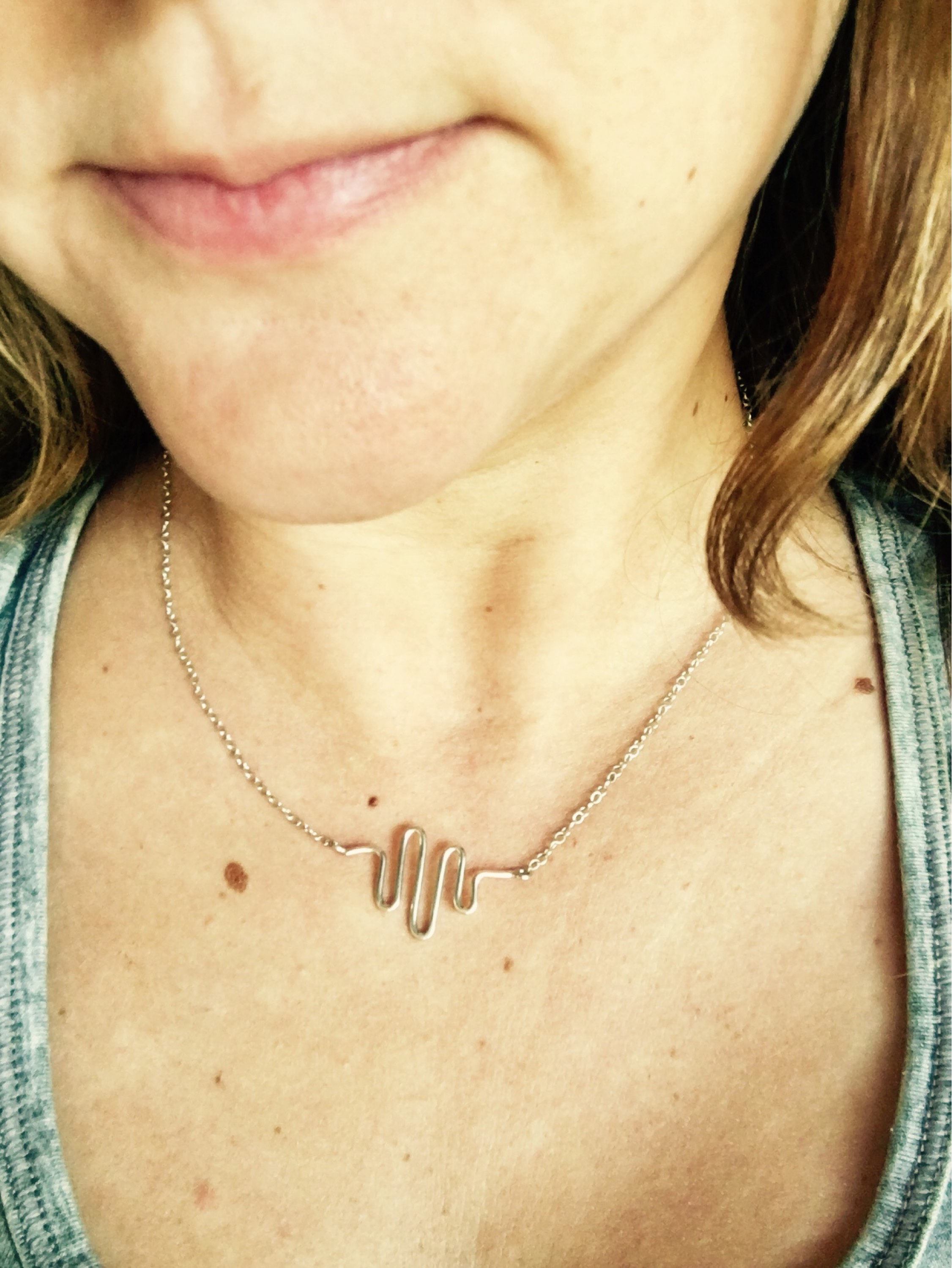 A handcrafted Heartbeat Necklace made from 16 gauge wire, featuring a unique heartbeat pendant attached to an adjustable chain.