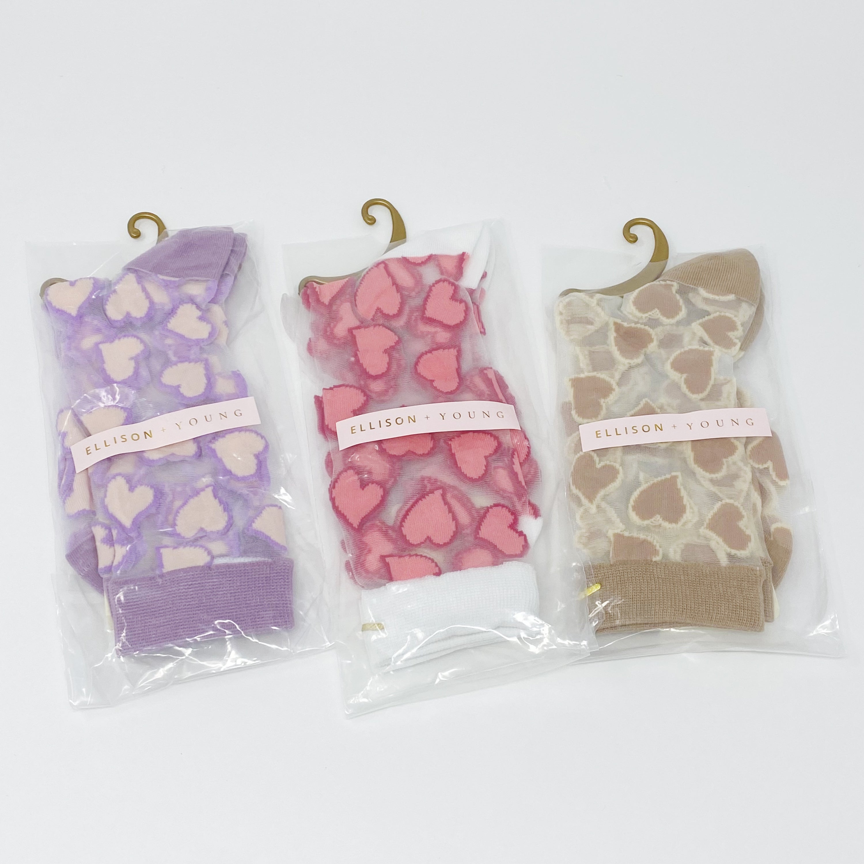 A pair of sheer socks featuring a playful heart pattern, showcasing their soft texture and stylish design.