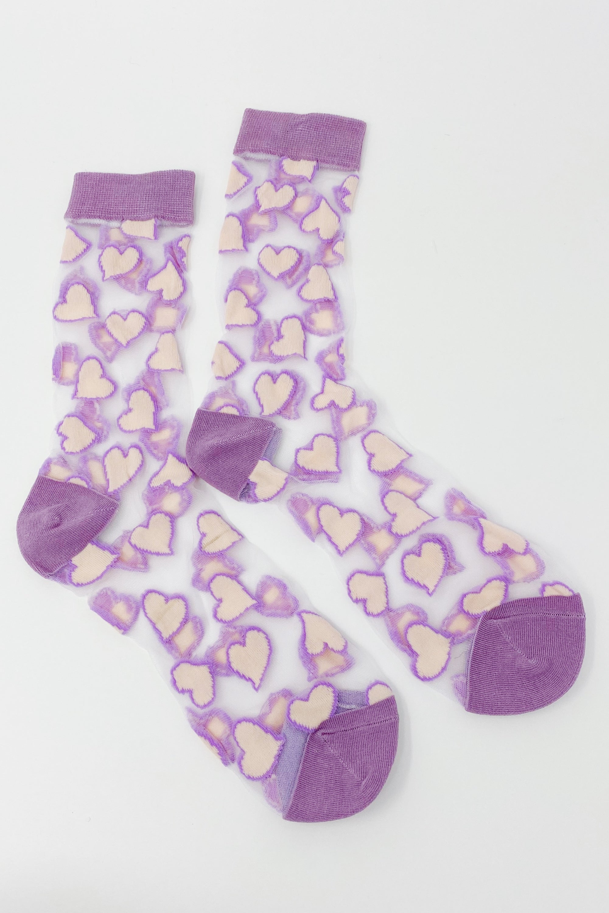 A pair of sheer socks featuring a playful heart pattern, showcasing their soft texture and stylish design.