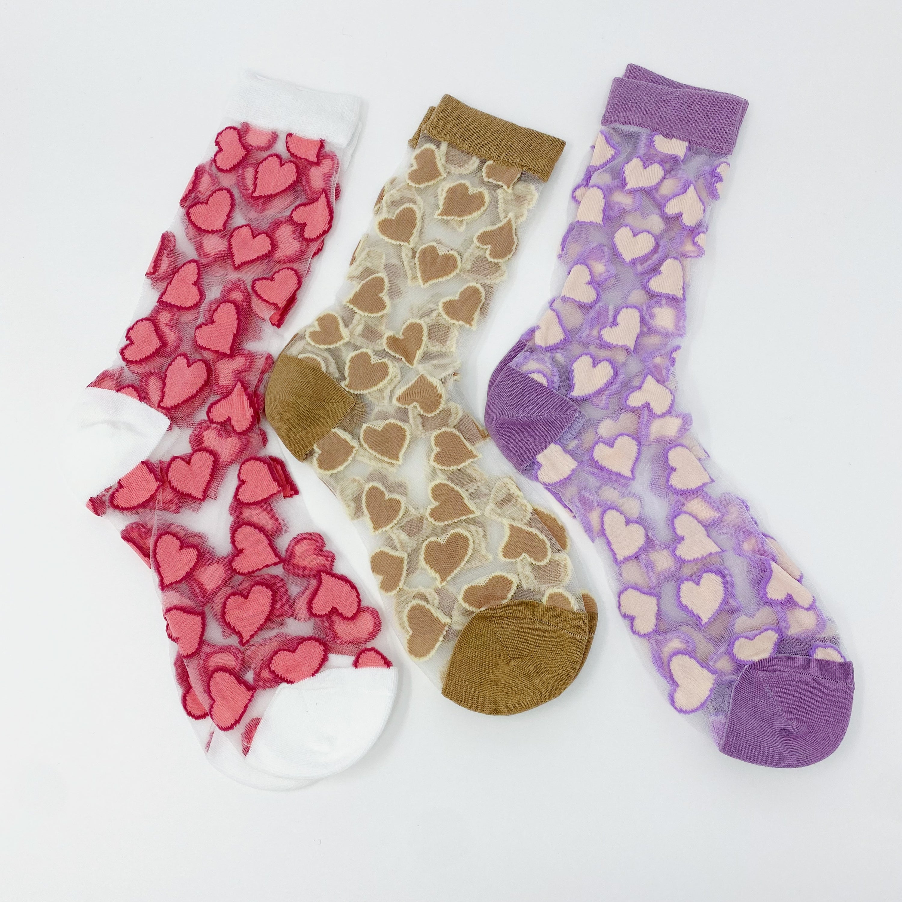 A pair of sheer socks featuring a playful heart pattern, showcasing their soft texture and stylish design.