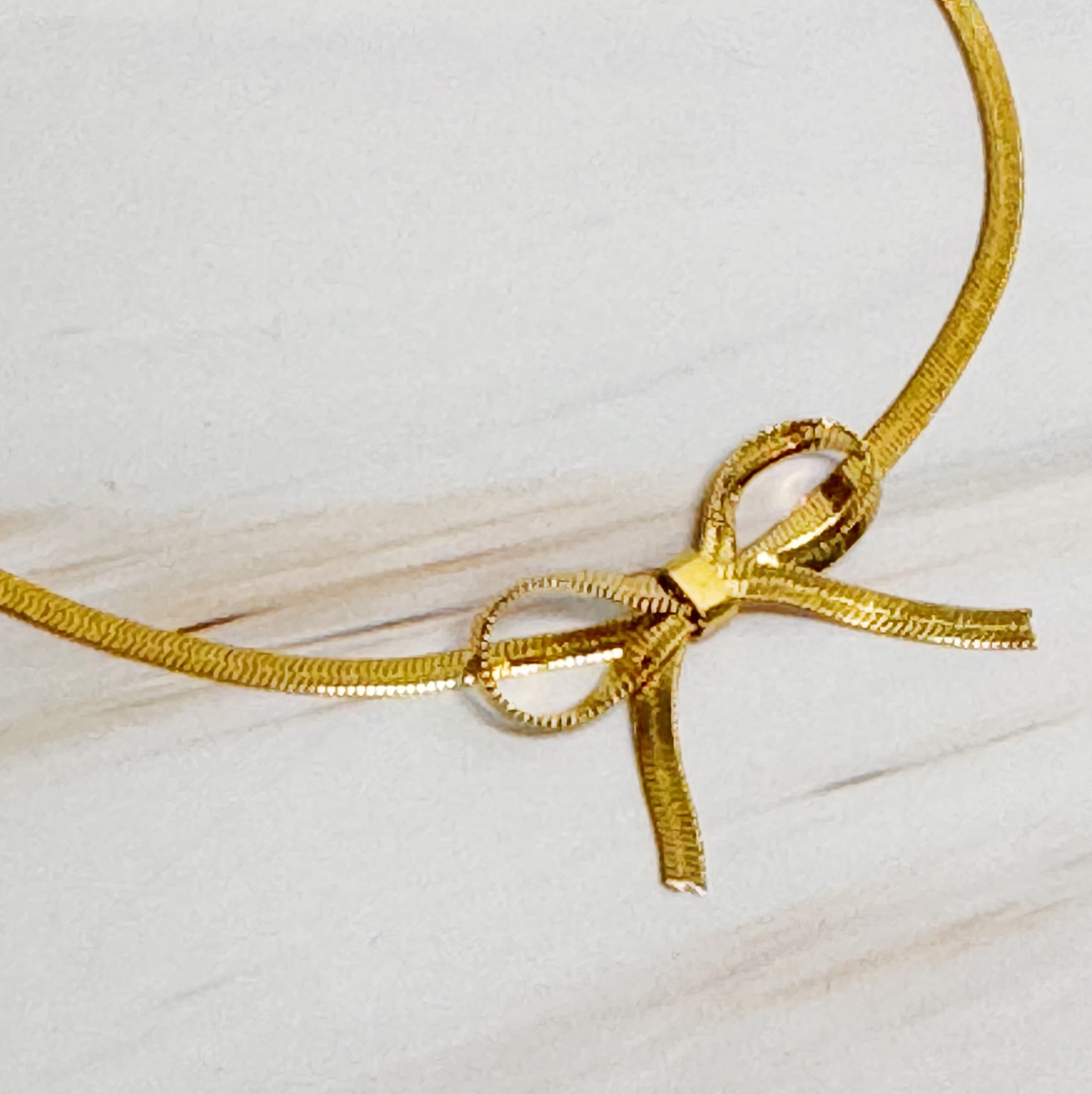 Elegant Herringbone Chain Bow Anklet in 18k gold plated brass with a delicate bow design.