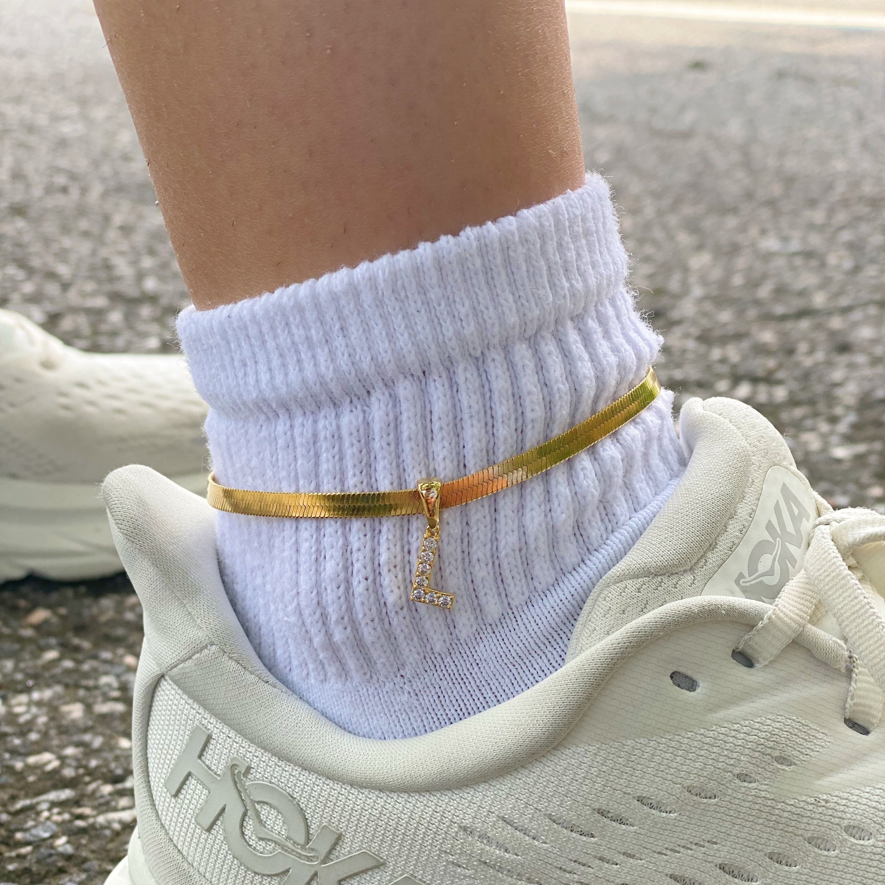 Elegant Herringbone Chain Initial Anklet with shiny initial charm, showcasing its gold plating and adjustable length.