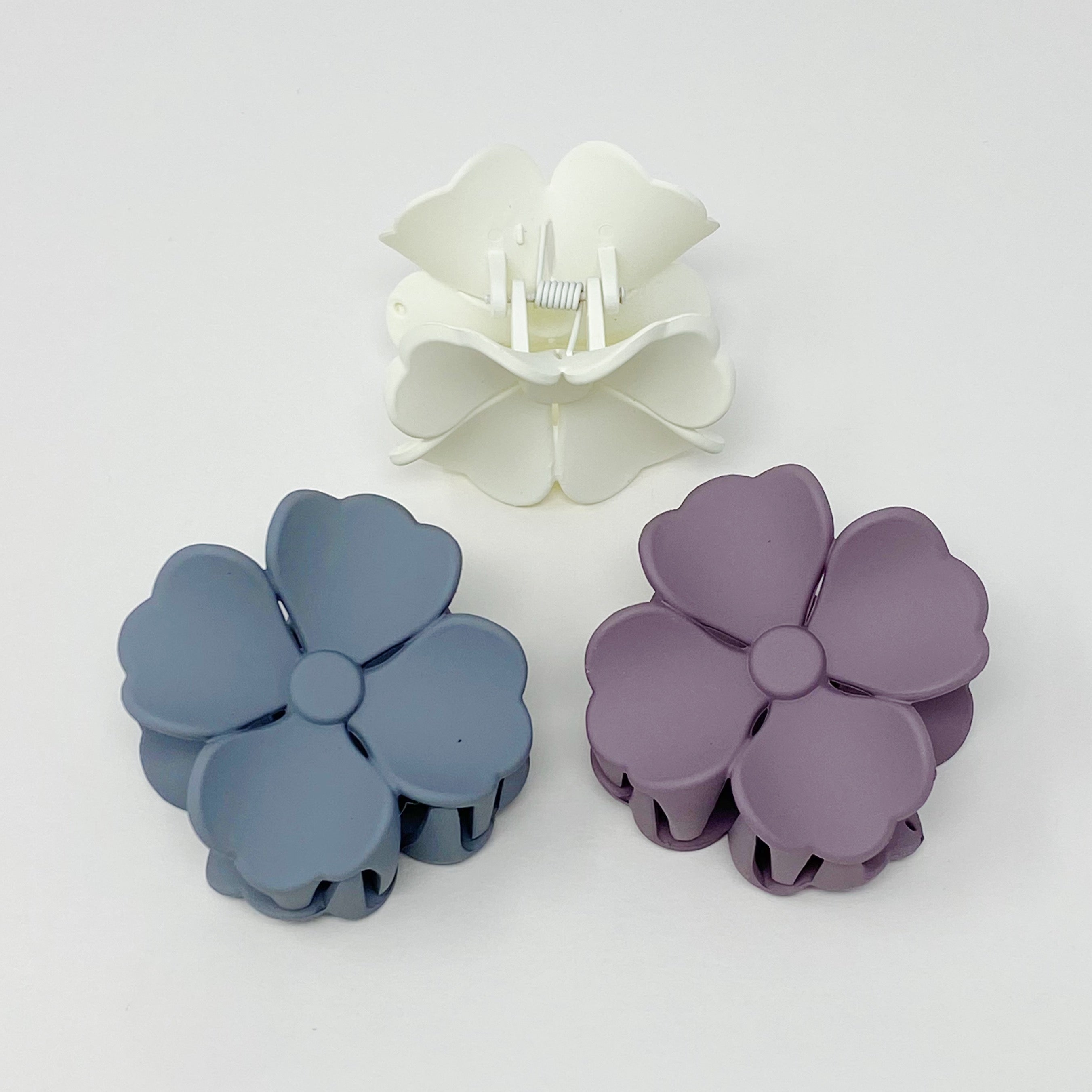 Set of 3 vibrant hibiscus flower hair claws with a matte finish, beautifully packaged in a clear cello bag.