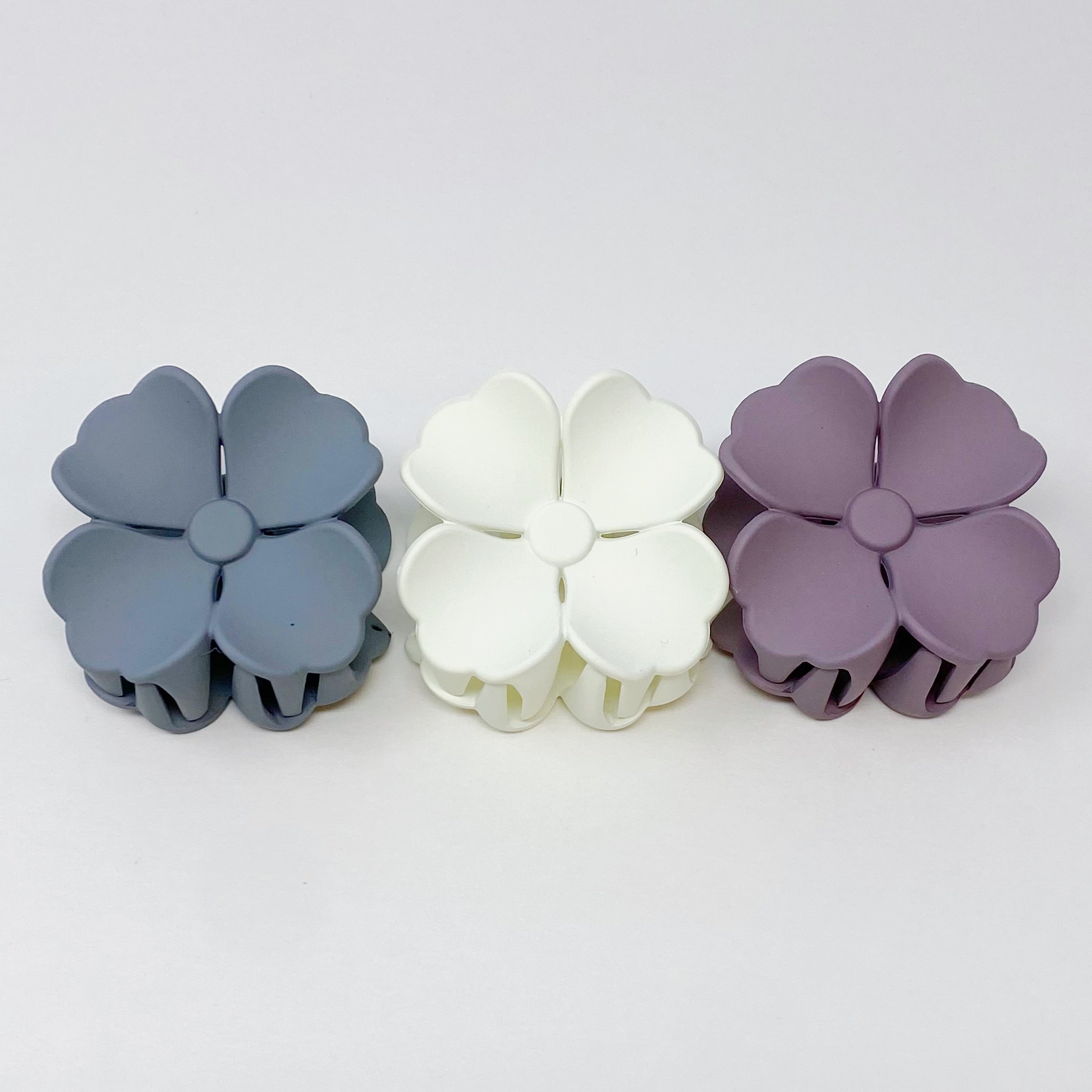 Set of 3 vibrant hibiscus flower hair claws with a matte finish, beautifully packaged in a clear cello bag.