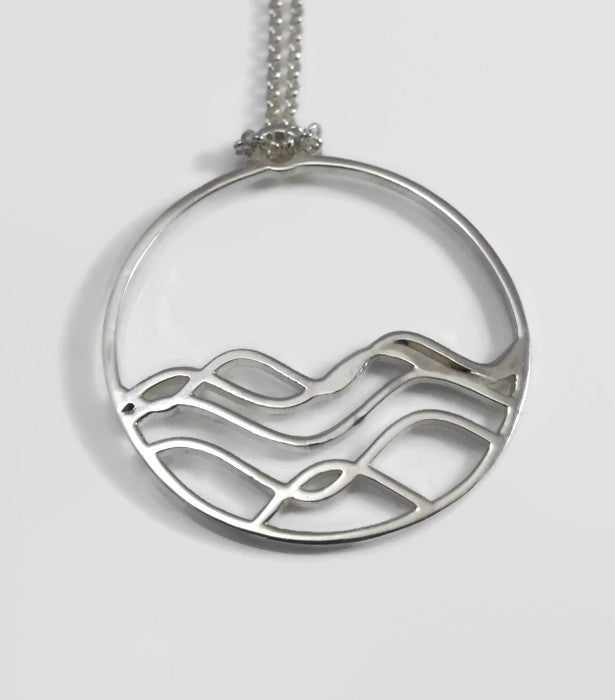 High Tide Ocean Wave Pendant in sterling silver, featuring a circular design inspired by ocean waves, displayed with a matching cable chain necklace.