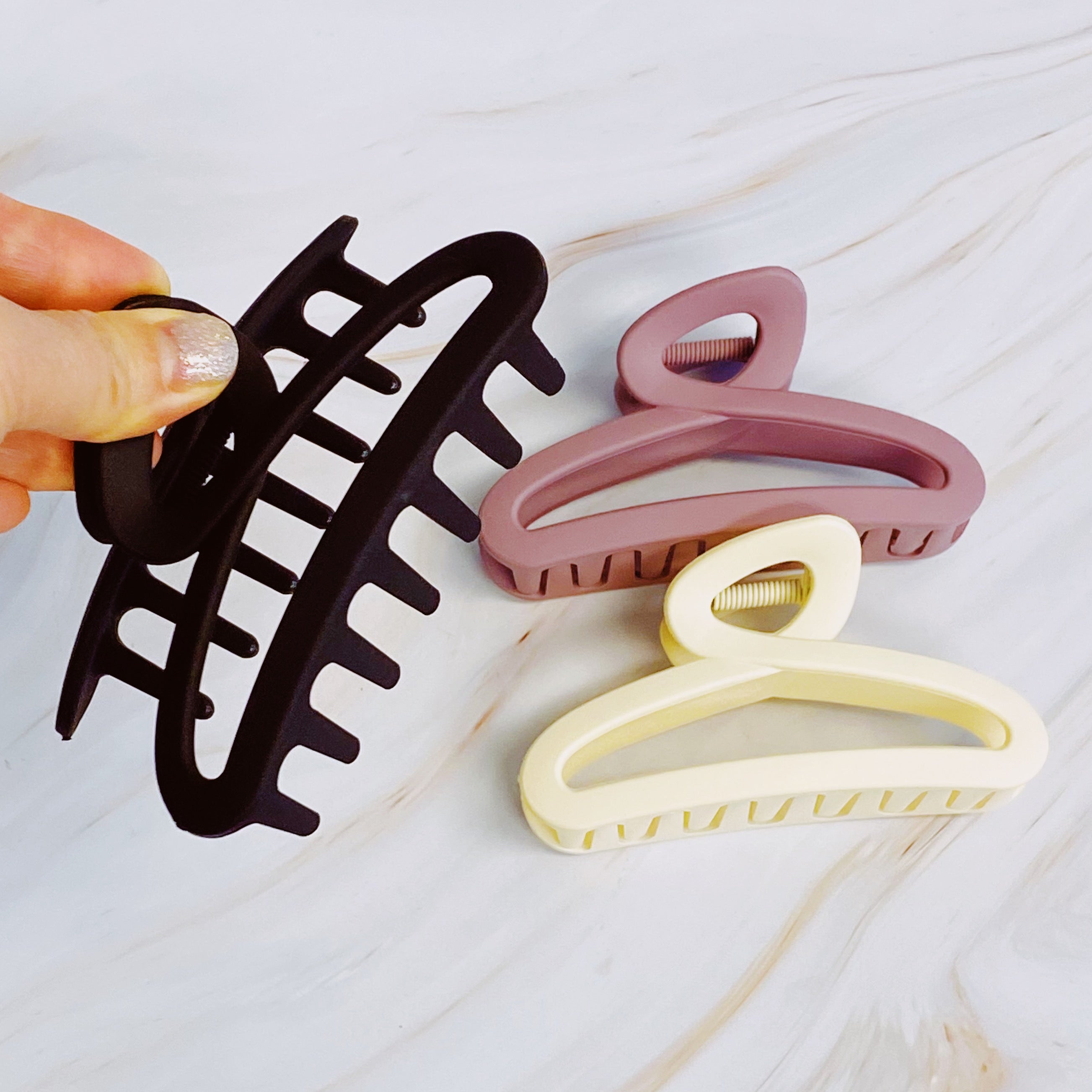 A stylish set of three hair claws in soft matte finish, showcasing various colors suitable for any hairstyle.