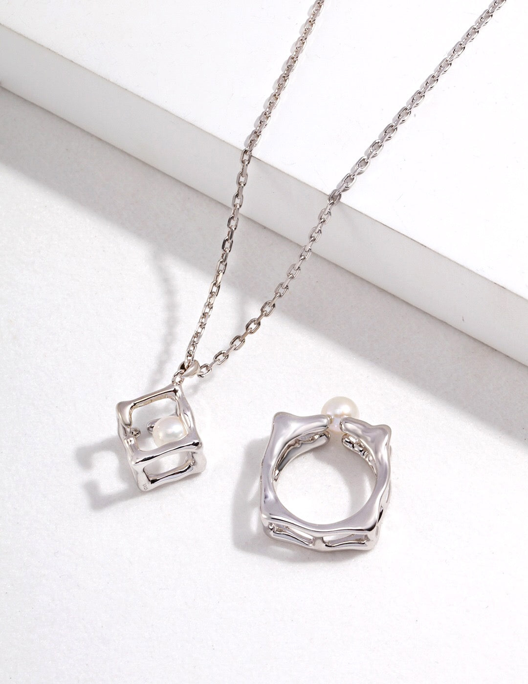 Hollow Geometric Cube Pendant Necklace featuring natural pearls and sterling silver, elegantly designed for a sophisticated look.