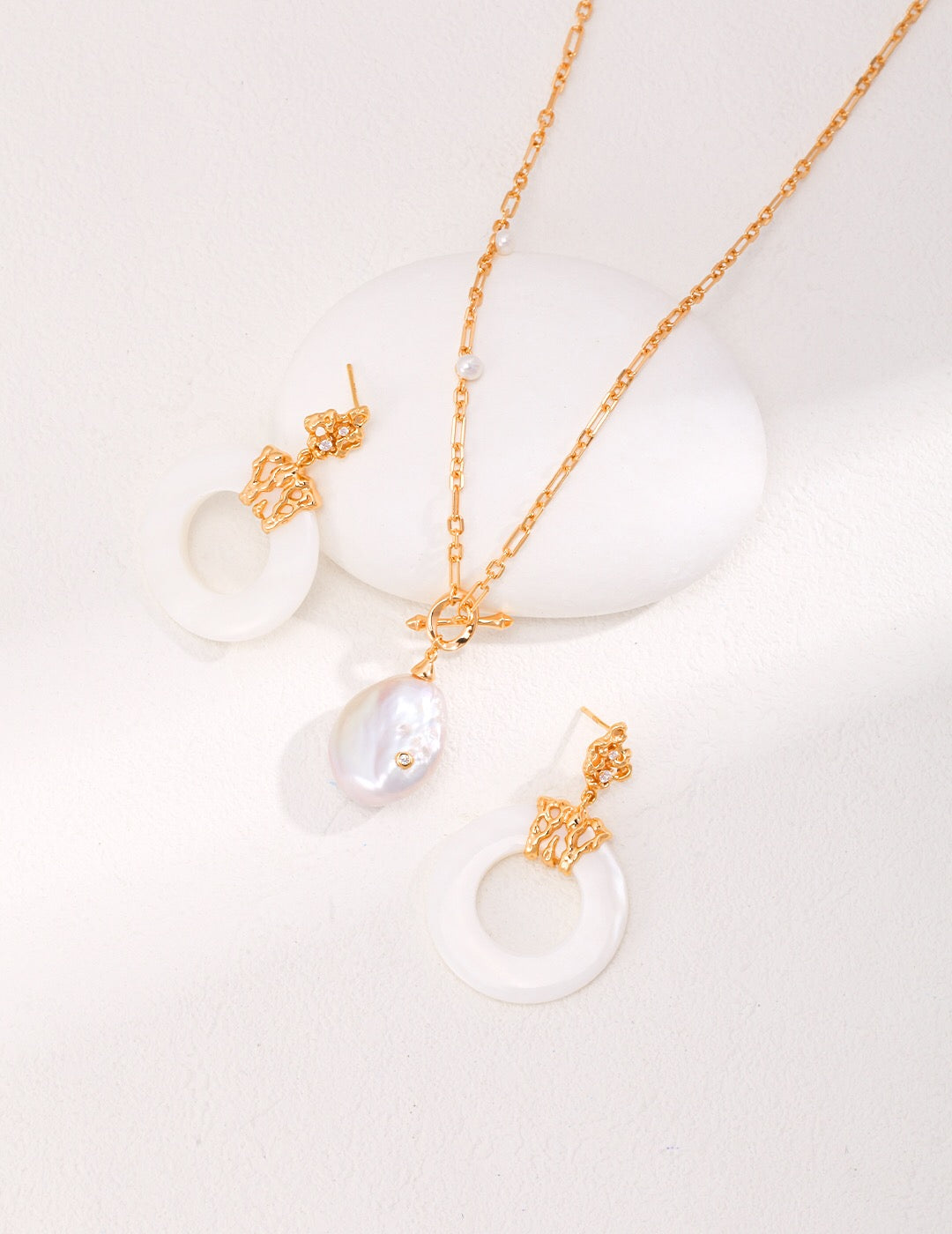 A pair of handmade Hollow Round Shell Drop Earrings featuring natural shell, sterling silver, and gold vermeil, elegantly displayed.