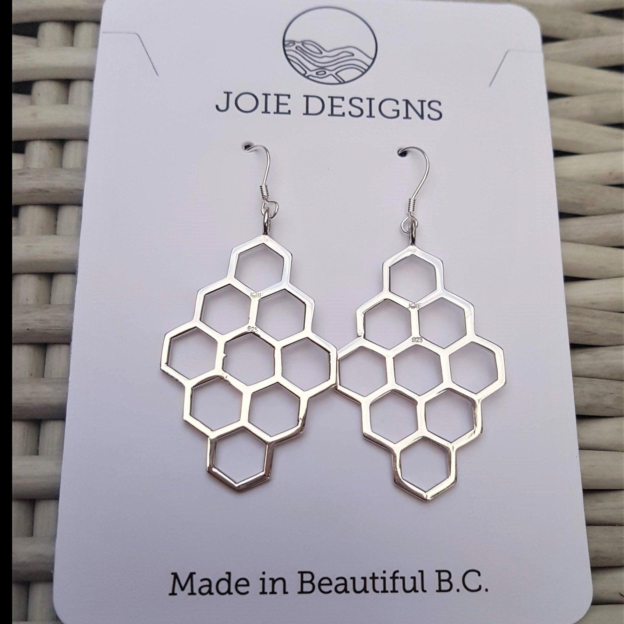 A pair of elegant sterling silver honeycomb earrings, showcasing a unique design with a polished finish.