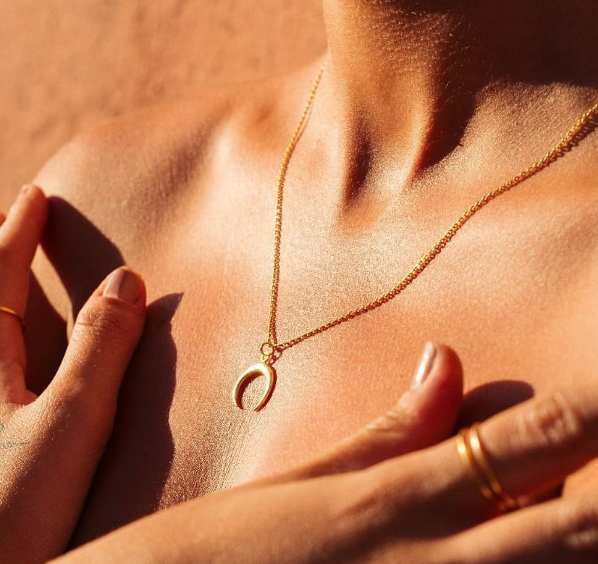 Elegant horn pendant necklace in gold and silver, featuring a minimalistic design on a delicate chain.